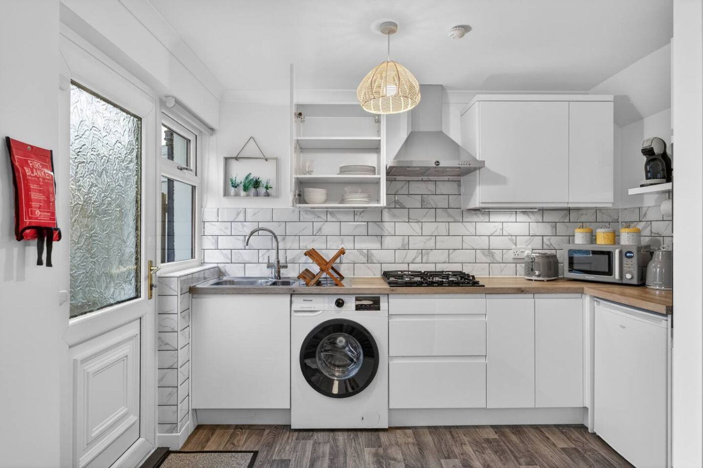 The Hide kitchen: gas hob, washing machine, and white cabinets.
